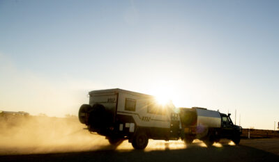 Birdsville, Australia - June 21, 2018: A 4wd towing a caravan is seen travelling along a dirt road on the South Australia/Queensland border in the late afternoon.
